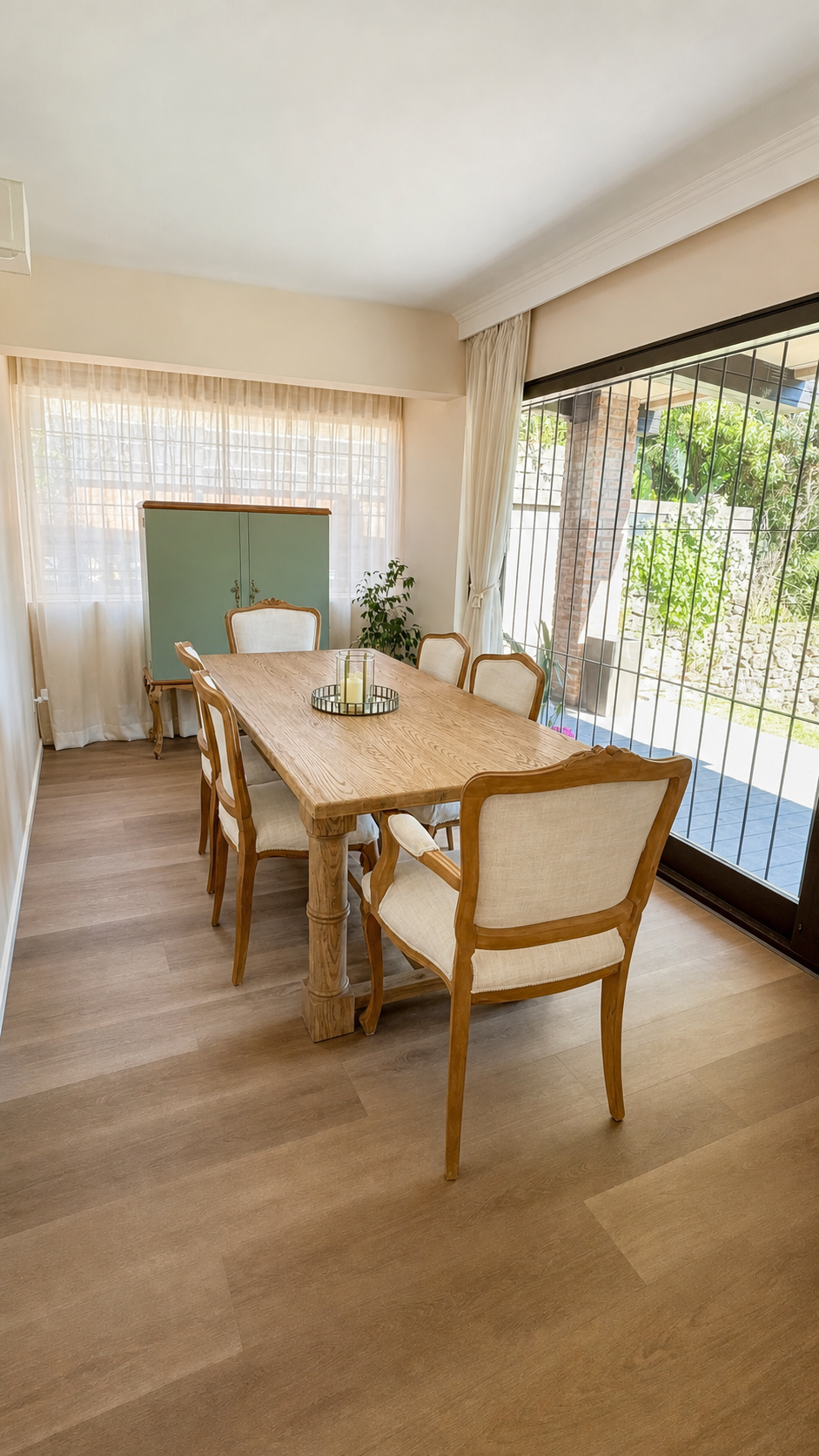 Mesa larga y sillas antiguas restauradas en un comedor luminoso