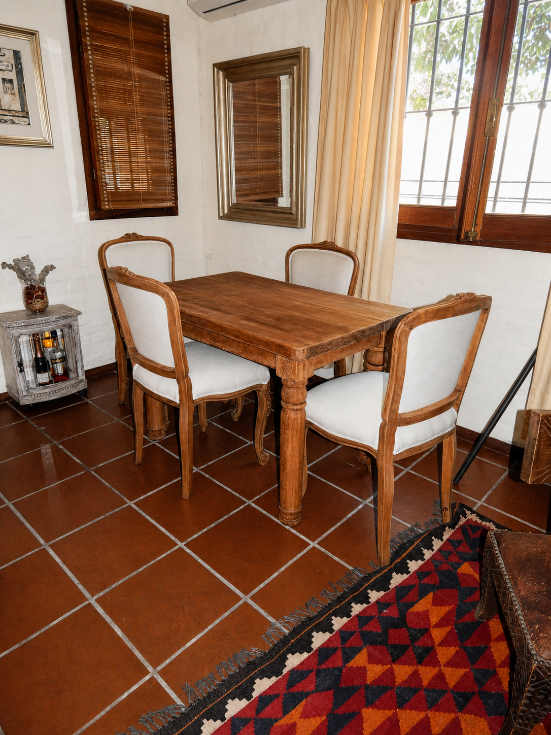 Mesa de madera y sillas clásicas restauradas con tapizado claro